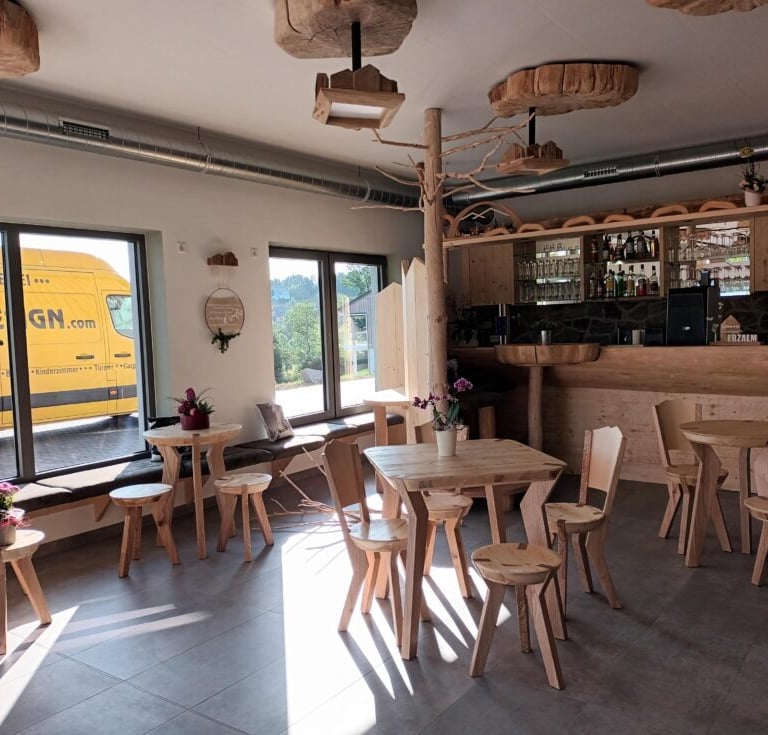 Hotelbar aus Massivholz mit ausgefallenen Sitzgruppen und Deckenlampen aus Baumscheiben