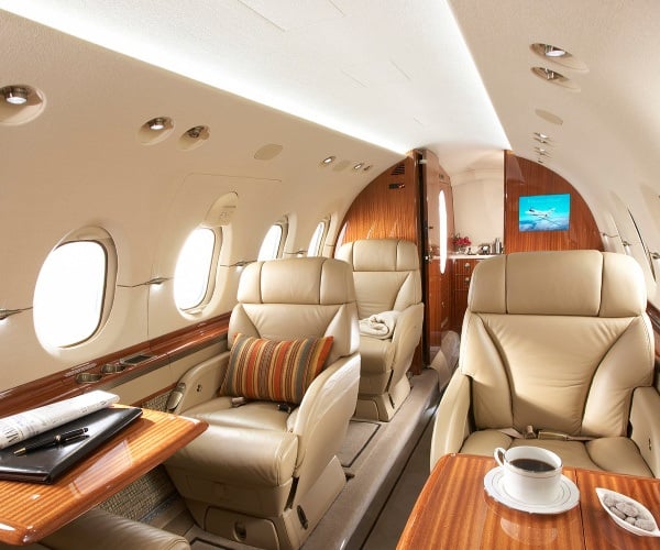 Elegant private jet interior with plush leather seating, wood finishes, and VIP amenities. Ideal for executive travel, busine
