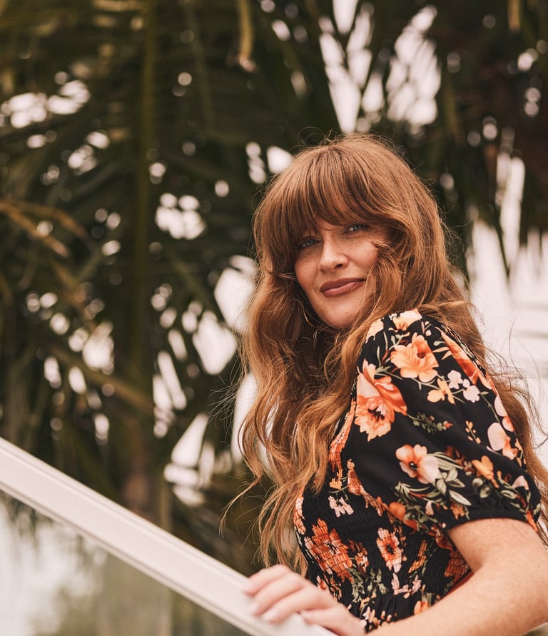 Fashion photography - a woman in a floral dress standing on a staircase