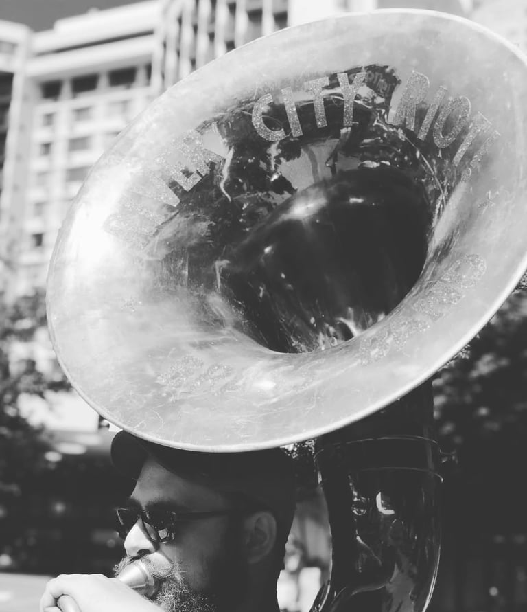 a man with a sousaphone tuba, brass band, portland oregon, mardi gras, new orleans music