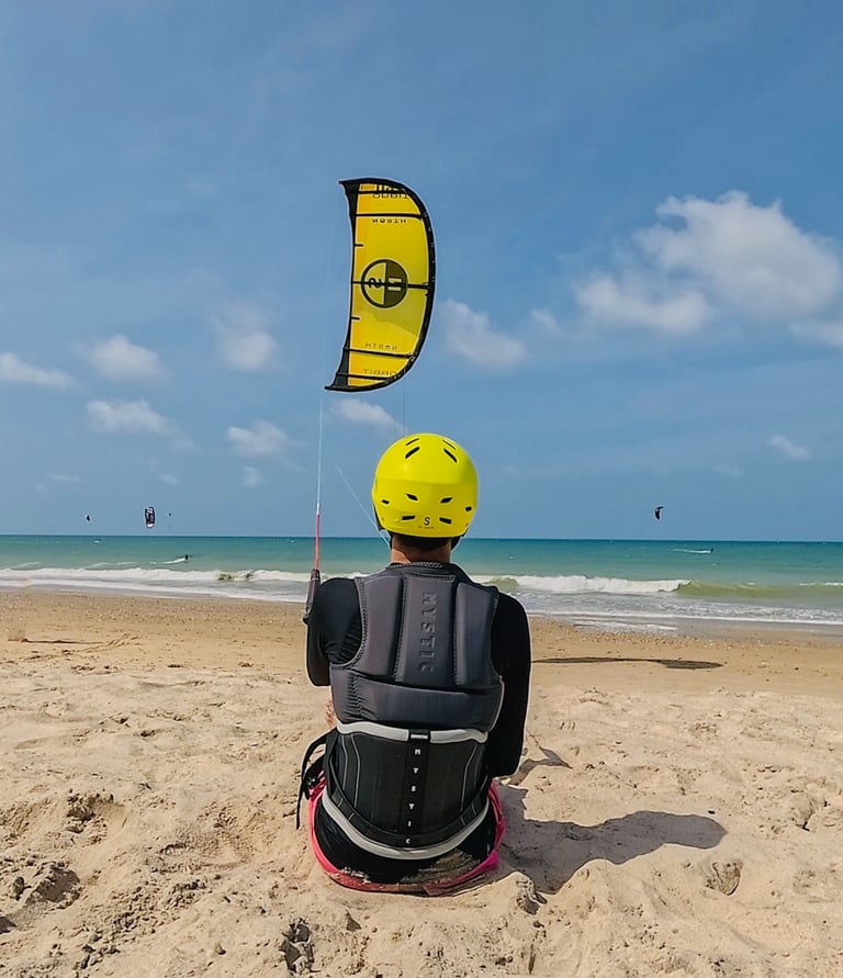 adolescente controlando o kitesurf de frente para a o mar.