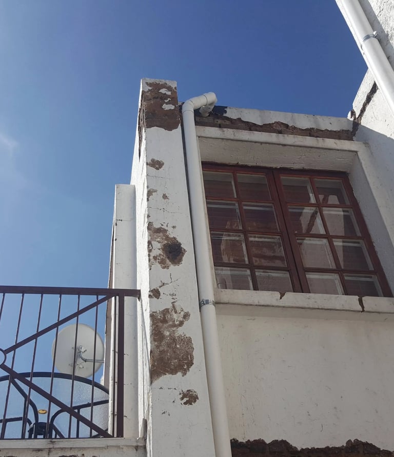 Weather-Exposed External Wall with Moisture and Plaster Erosion