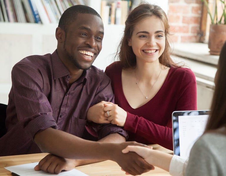 a man and woman shaking hands in a meeting