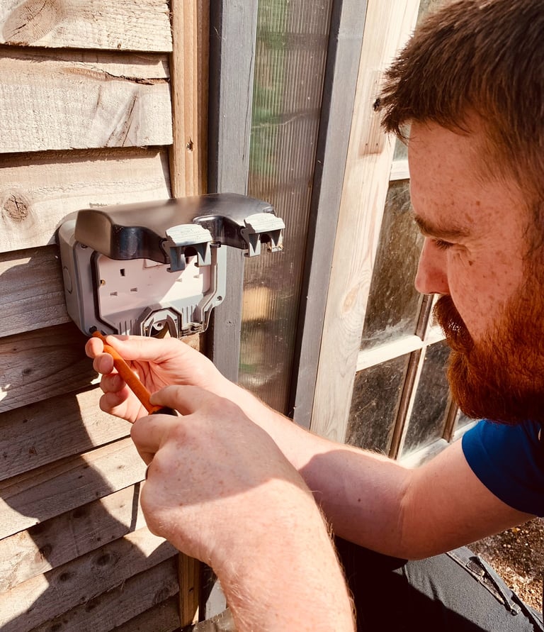 GigaVolt electrician installing an outdoor power socket