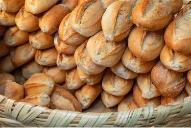 Una canasta tejida rebosante de panecillos artesanales recién horneados, de corteza crujiente,