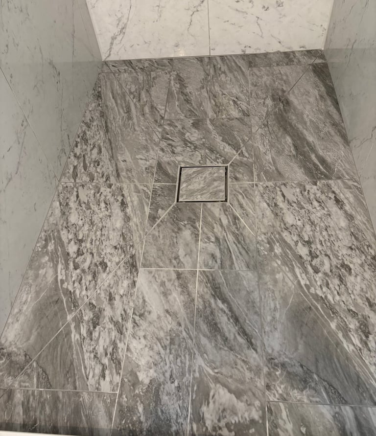 Modern walk-in shower featuring envolpe cut porcelain tiles for base.