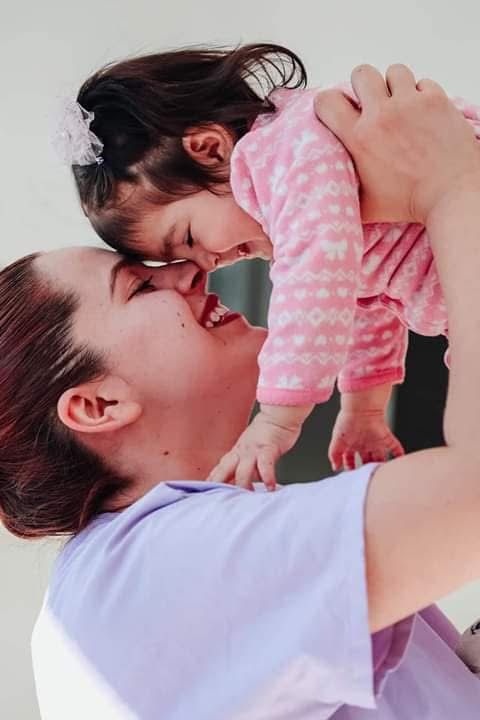 Madre feliz levantando a su bebé sonriente, compartiendo un momento de vínculo afectivo y conexión e