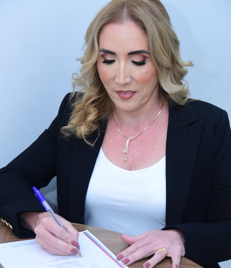Professional businesswoman in a black blazer signing a formal document with a blue pen.