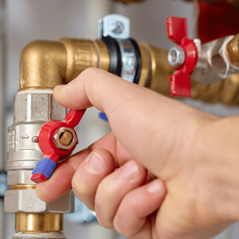 Absperrventil an Heizungsanlage wird von Hand geöffnet oder geschlossen – moderne Gebäudetechnik