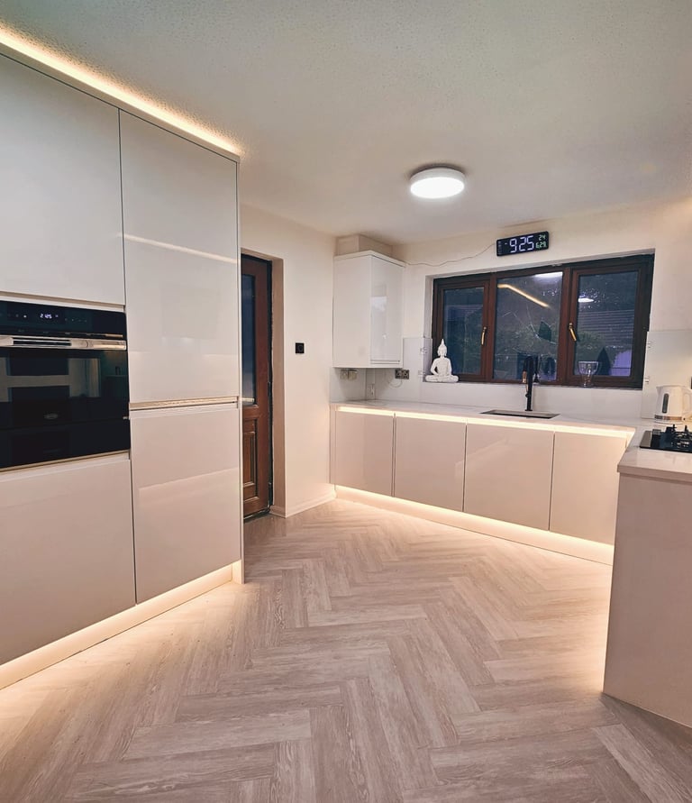 Moern all white kitchen with back lighting on cupboard storage