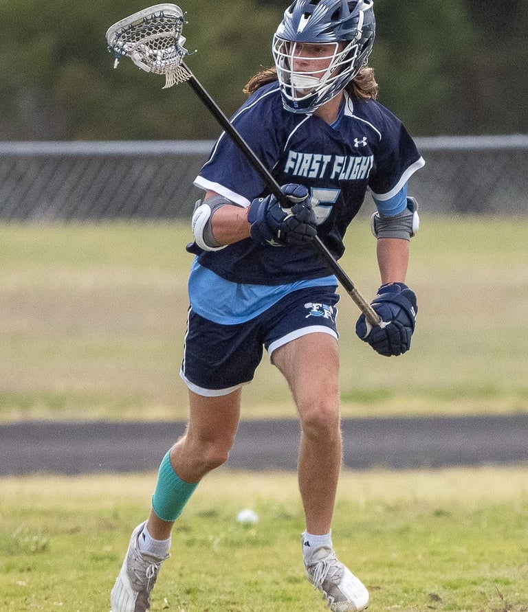 First Flight lacrosse player, Cam Van Lunen, playing defense.