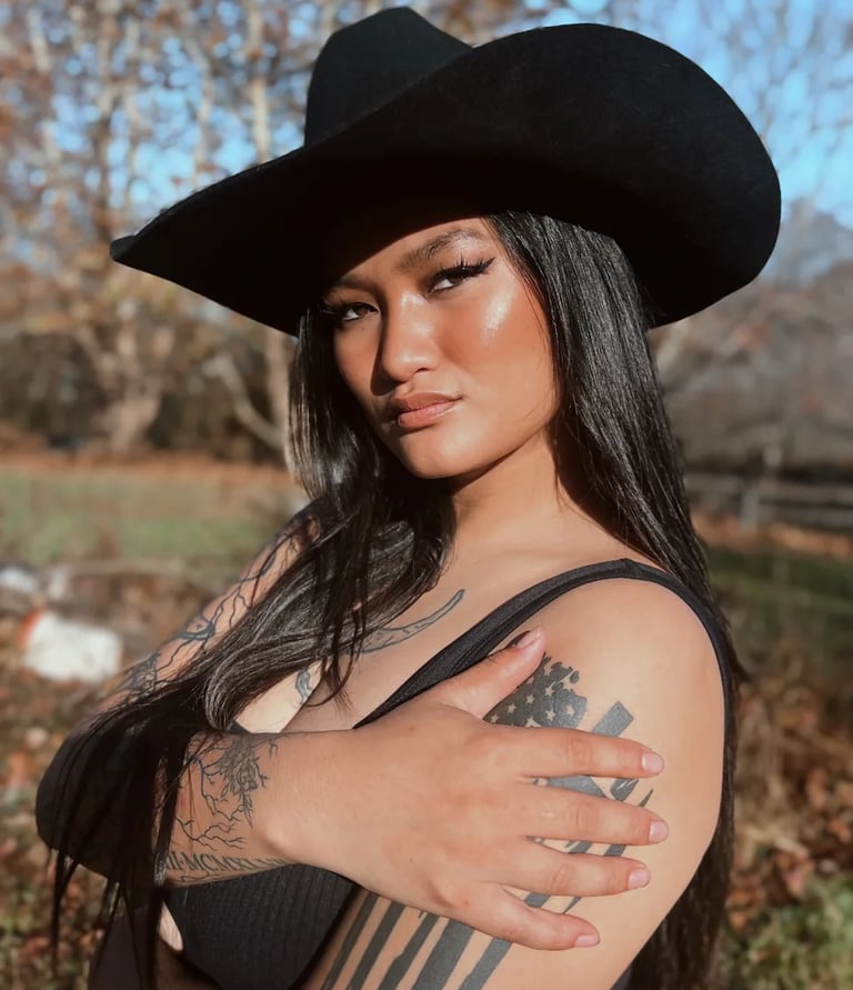 Amelia posing outside in a black cowboy hat