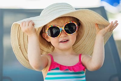 criança com chapéu de praia