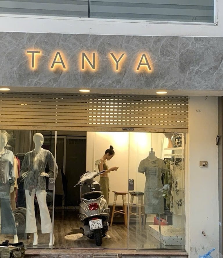 Biển hiệu TANYA cho Shop thời trang, nền giá đá chữ hiển thị là chất liệu Inox xước bạc có đèn lánân