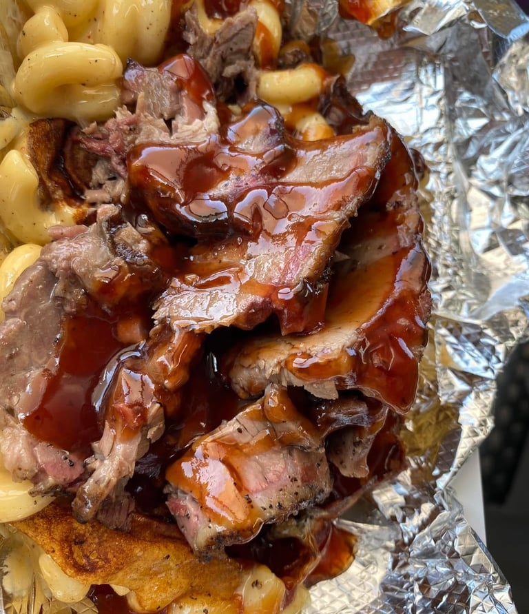 Signature One Eye Willy brisket mac and cheese—Texas-style smoked brisket over four-cheese macaroni with BBQ drizzle, served 