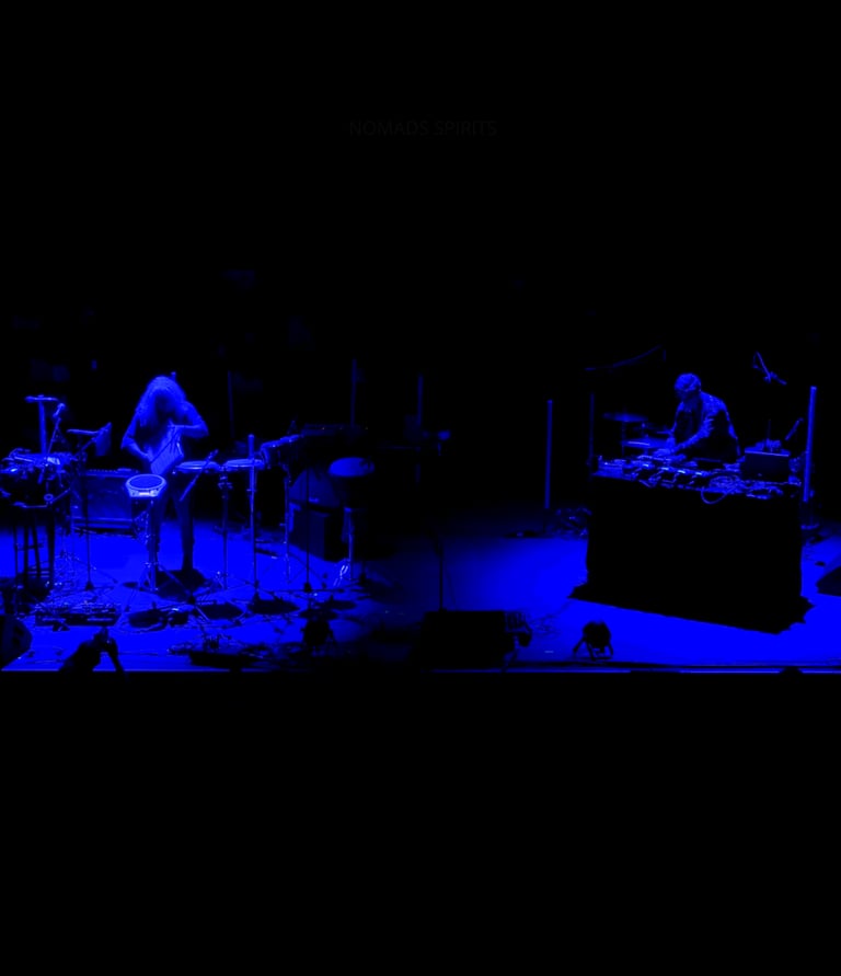 Nomads Spirits duo live performance, trumpet and percussion under blue stage lights