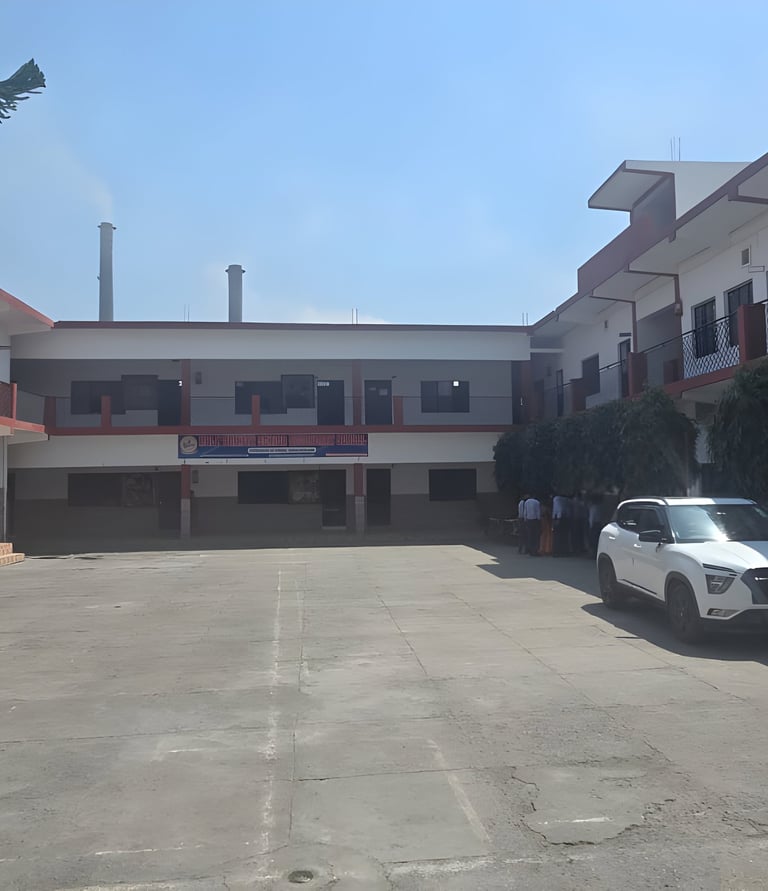Two-story white school building with a large open paved courtyard