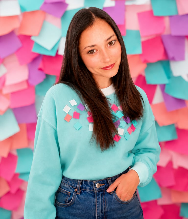 Créatrice au style coloré devant un mur de post-it, l'univers créatif de M.I.U.