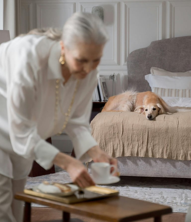a woman in a white shirt and a dog on a bed