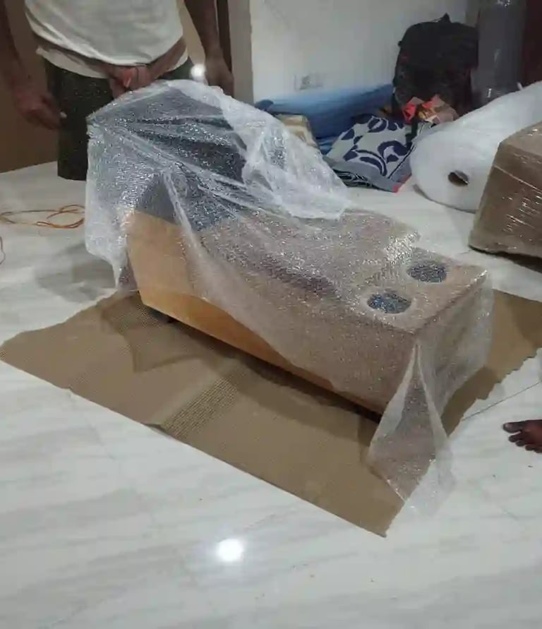Professionally packed sofa wrapped with plastic stretch film and cardboard for household shifting.