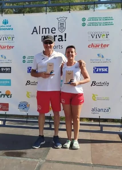 Atletas enseñando el trofeo de primeros en la travesia de almenara