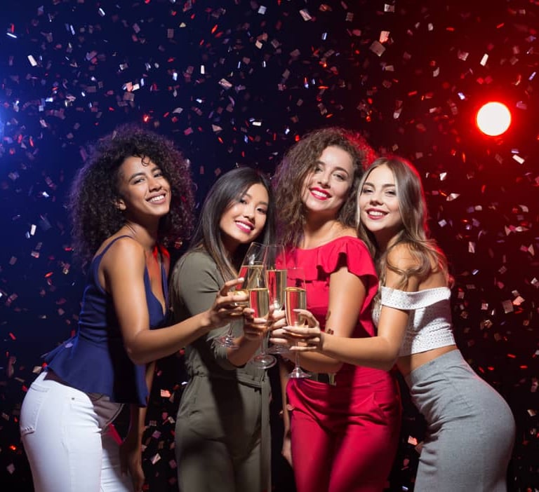 Group of women celebrating at a VIP nightclub party in Las Vegas, holding champagne glasses and enjoying the night.