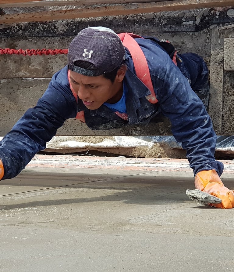 Operario fratachando revoque en altura con balancín