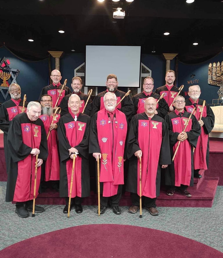 a group of men in red robes standing in front of a stage
