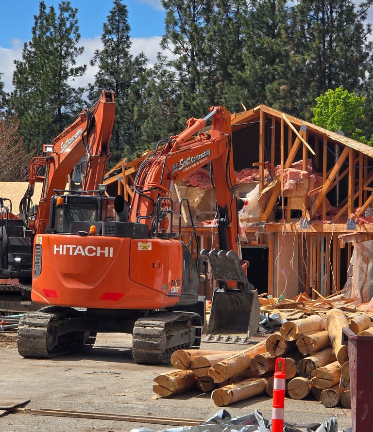 Two Excavators demolishing a structure