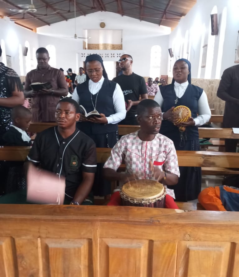 Catholic nuns and parishioners singing and playing traditional drums during a church service.