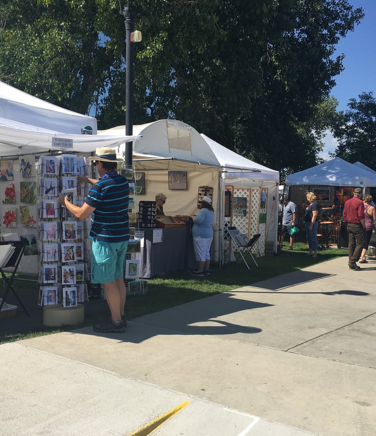 Art booths at Art in the Park with people walking around shopping for art