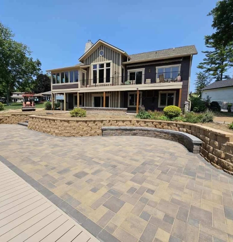 A custom paver patio, retaining wall, and bench by Kingdom Landscape in Heritage Lake Indiana