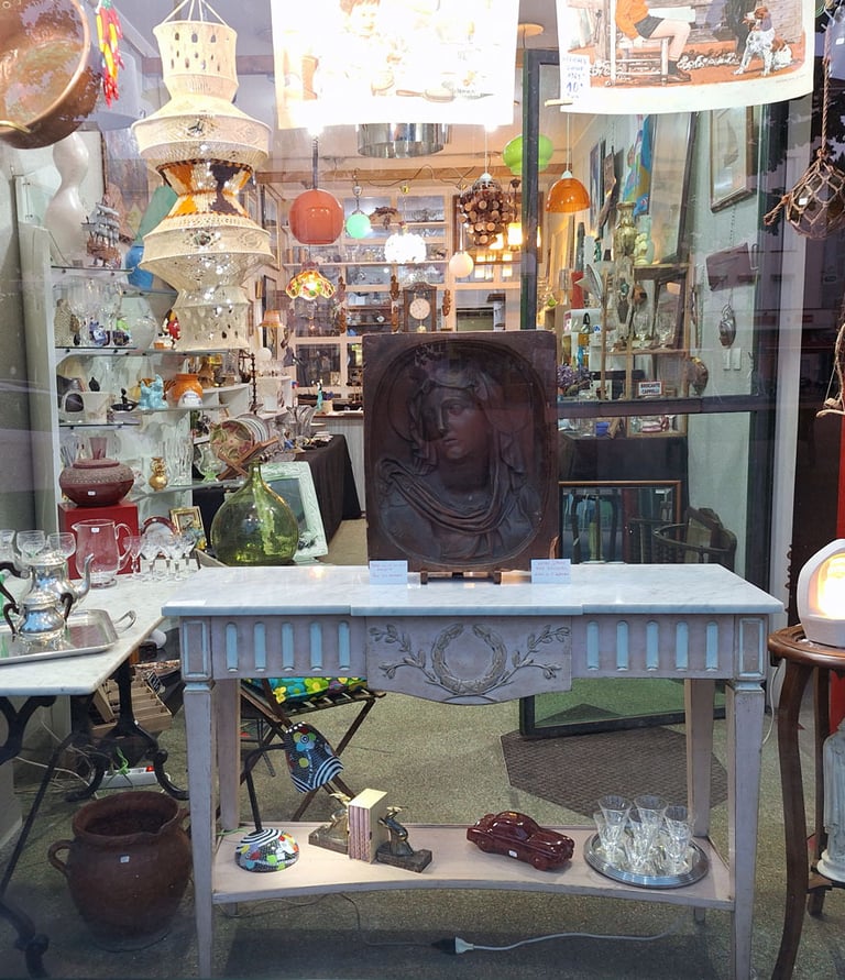 Vitrine de la brocante de l'Ardèche avec des petits meubles et nombreux bibelots.