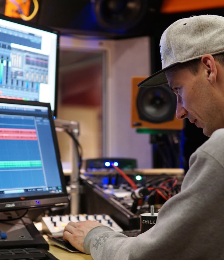 a man in a recording studio mastering tracks with cubase listen on a professional monitoring 