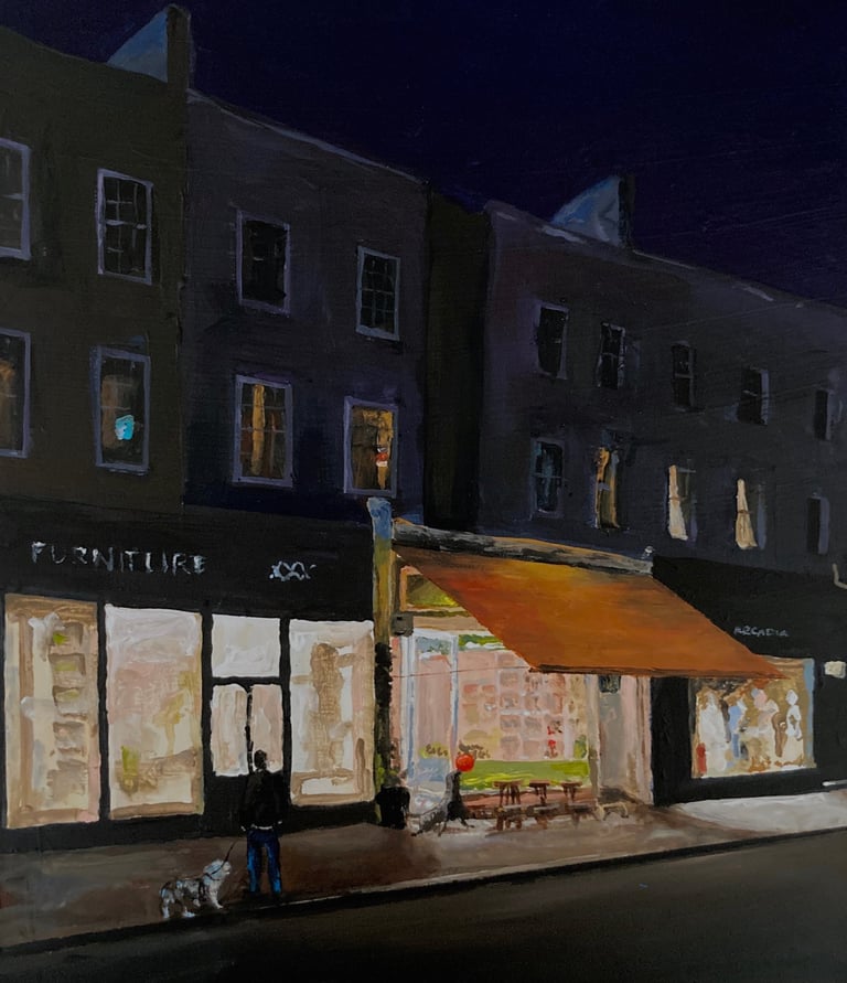 an early evening scene in London. a man is walking a dog and seal plays with ball outside a cafe