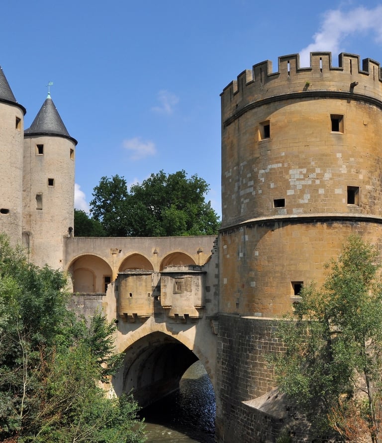 Vue extérieure de la Porte des Allemands à Metz, monument médiéval imposant composé de tours fortifiées, créneaux et mâchicou