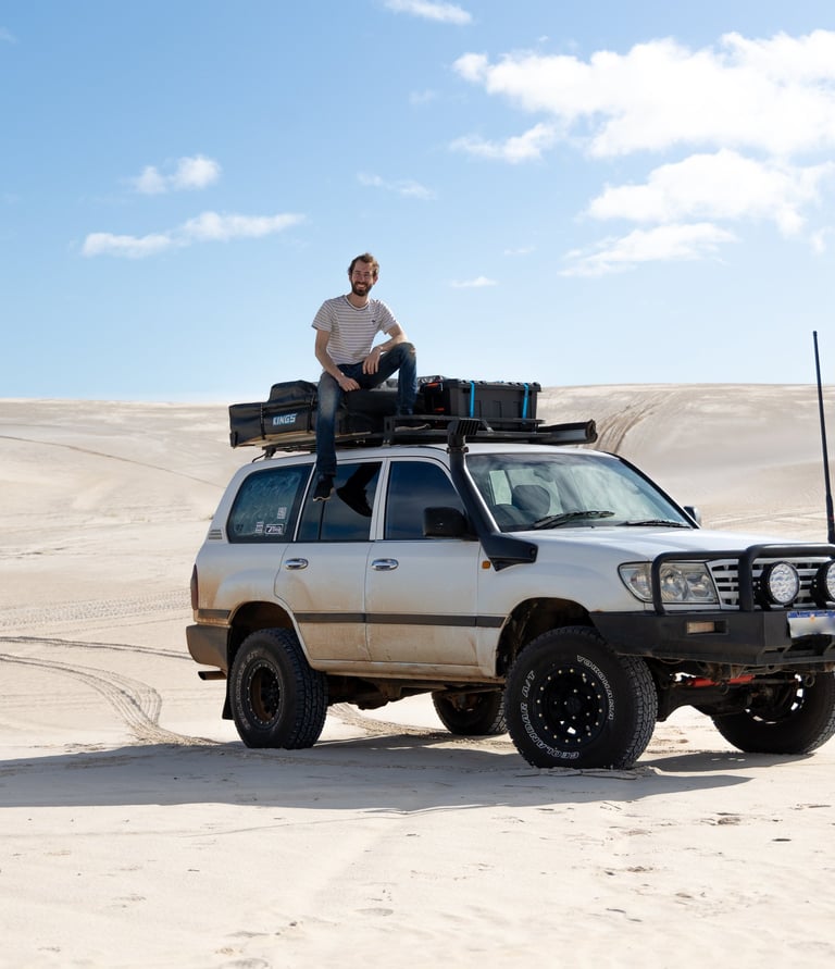 persoon zit op een 4x4 Toyota Lancruiser in de woestijn in West Australie