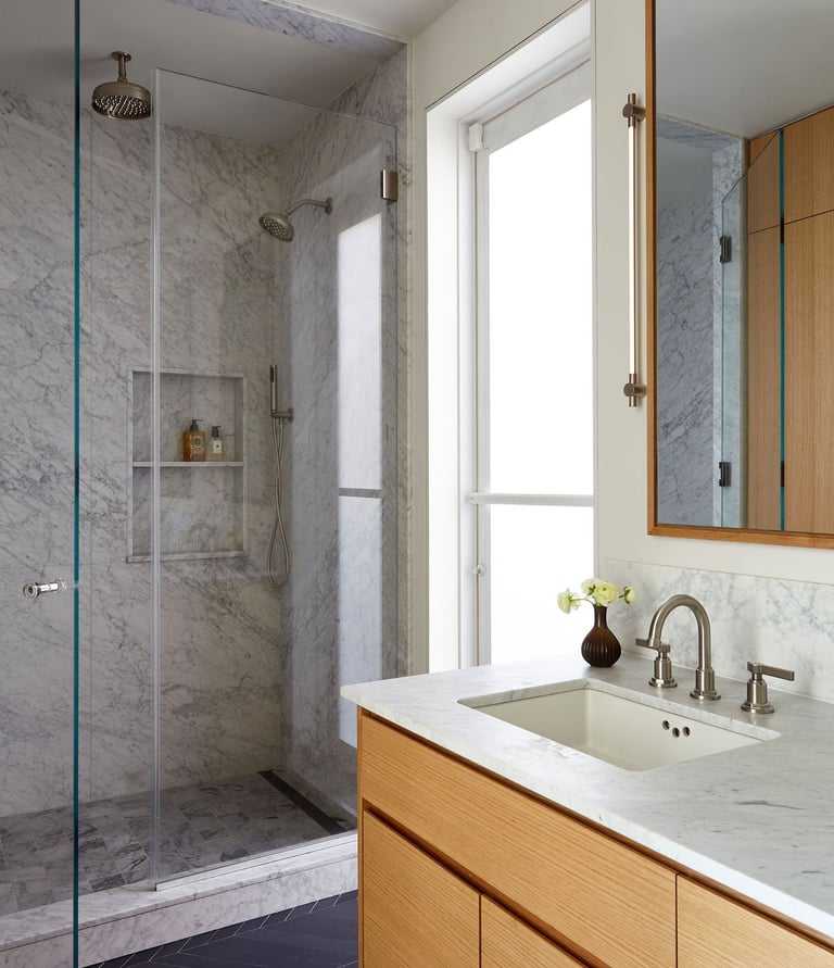 a bathroom with a marbled counter top and a shower