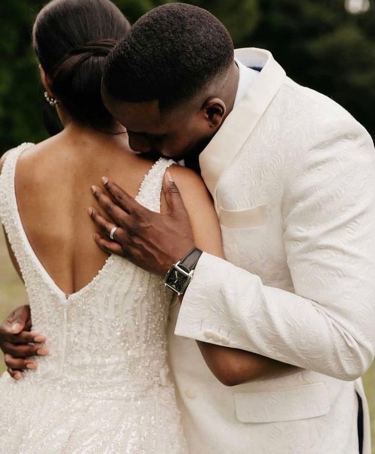 a bride and groom embracing each other in a field