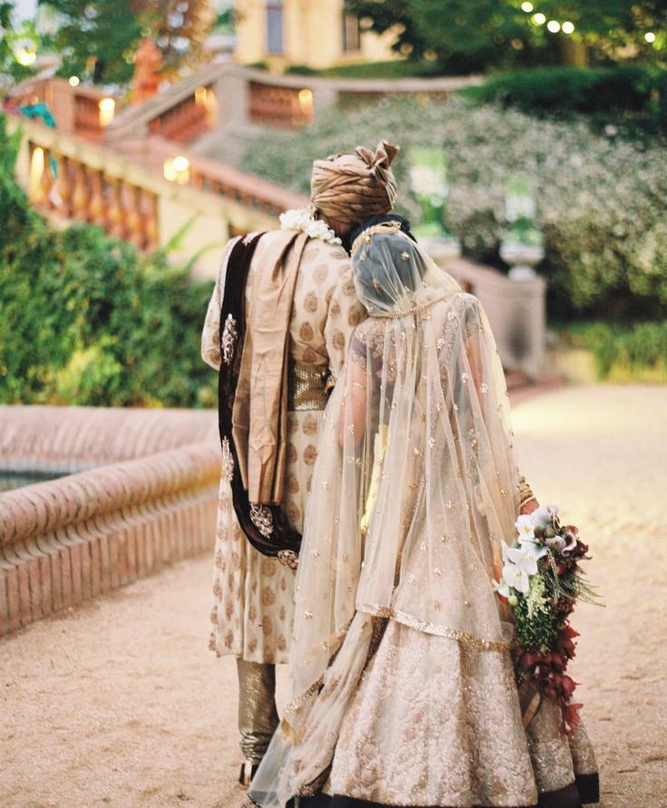 a bride and groom walking down a path