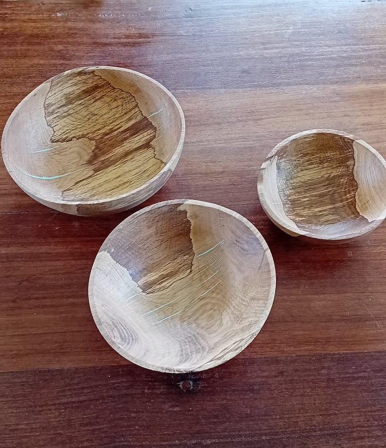 3 turned wooden bowls with thin turquoise kintsugi-style highlights, viewed from above