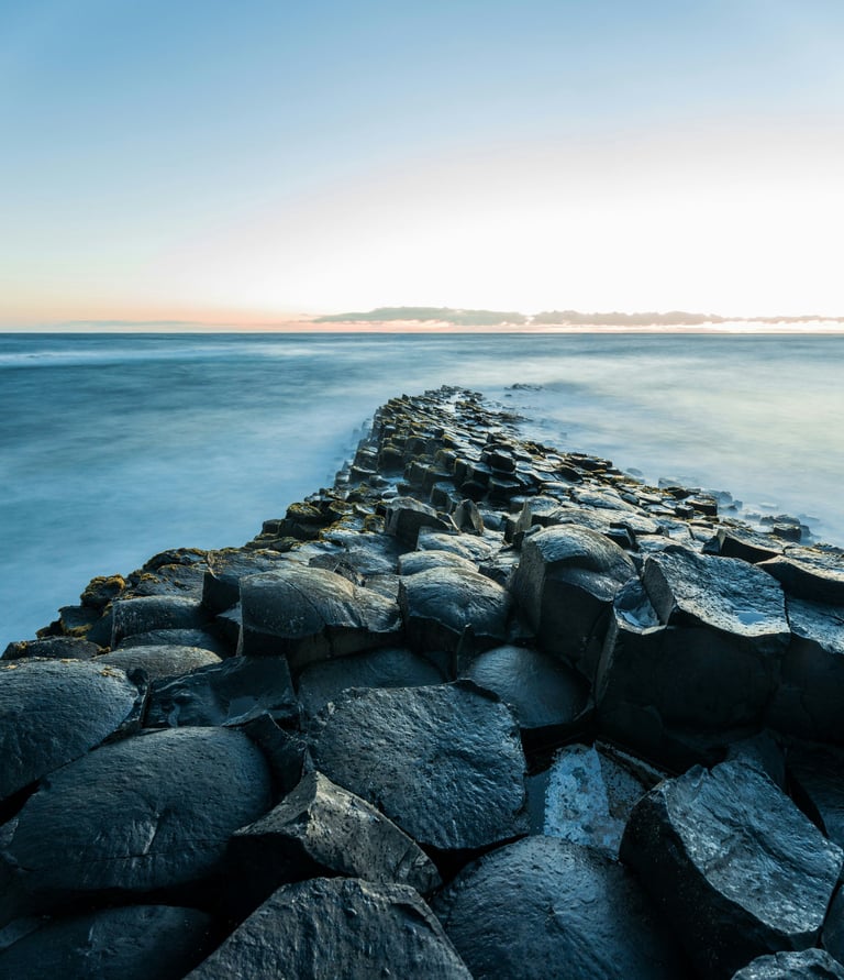 a long exposure of a rocky beach with a view of the ocean