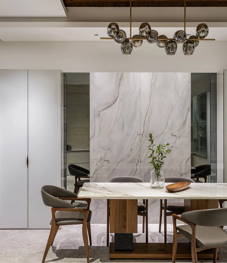 Modern dining room with marble wall and round table - Amuk Modular interior design Pune