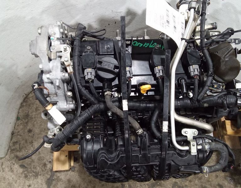 Used car parts with intake manifold and wiring harness on a pallet.