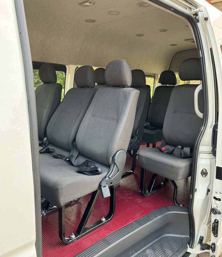 Interior of a white passenger commuter van with comfortable recliner seats