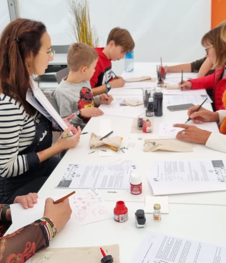 Photographie de Camille Poli encadrant un atelier pédagogique pour enfants et adultes