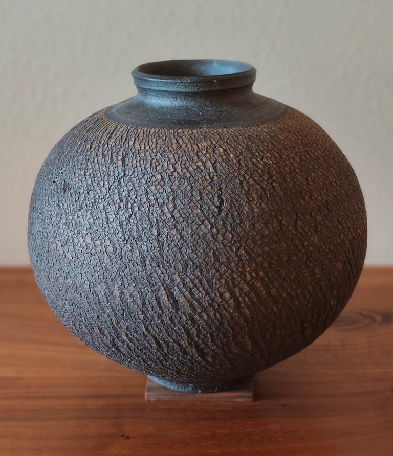 wheel-thrown moon jar with sodium silicate texture, coated with black underglaze and high fired