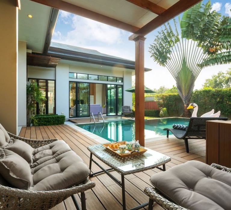 a patio with a pool and a lounge area