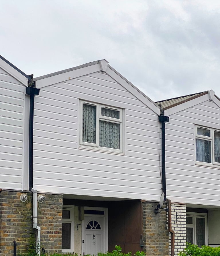 A hous with white panel top floor and double galzing window