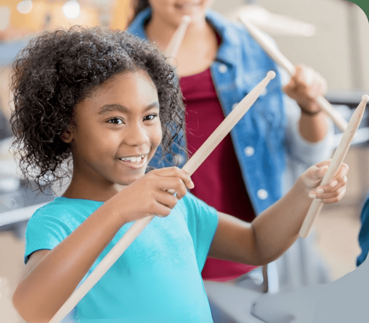 child smiling playing drums